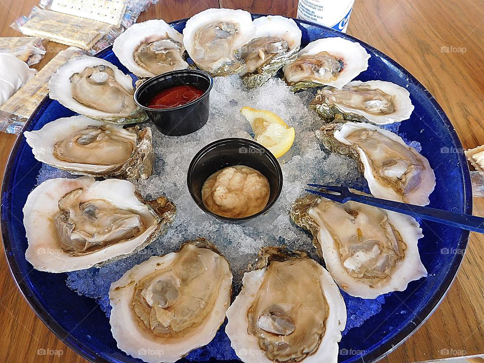 Raw Oysters on the Half Shell served with horseradish, lemon, cocktail sauce, lemon wedges and saltine crackers. 