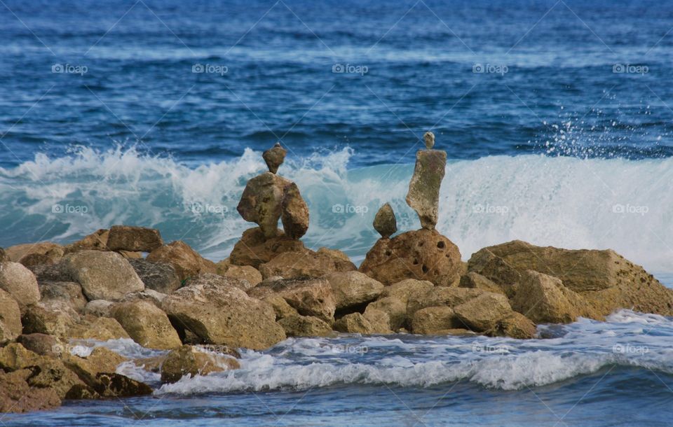 Waves rolling in behind stacked rocks at the beach 
