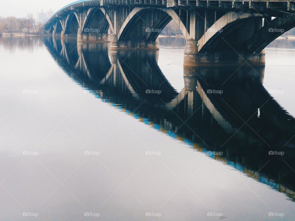 mirror image of the bridge in the Dnieper river