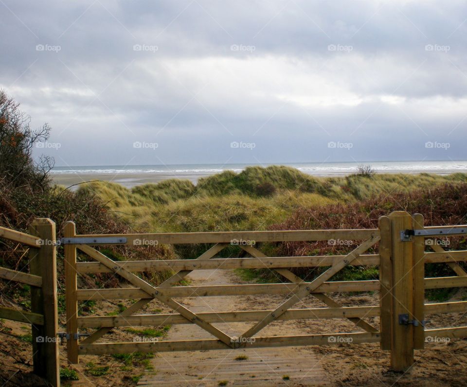 Walking through a wooden gate to the seashore