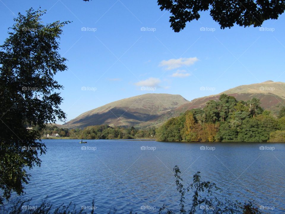 the lake and the fells with trees framing them