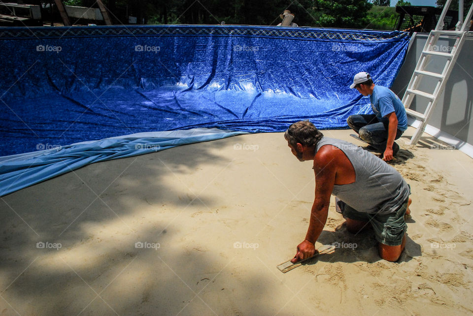 Workers Installing an Above Ground Swimming Pool