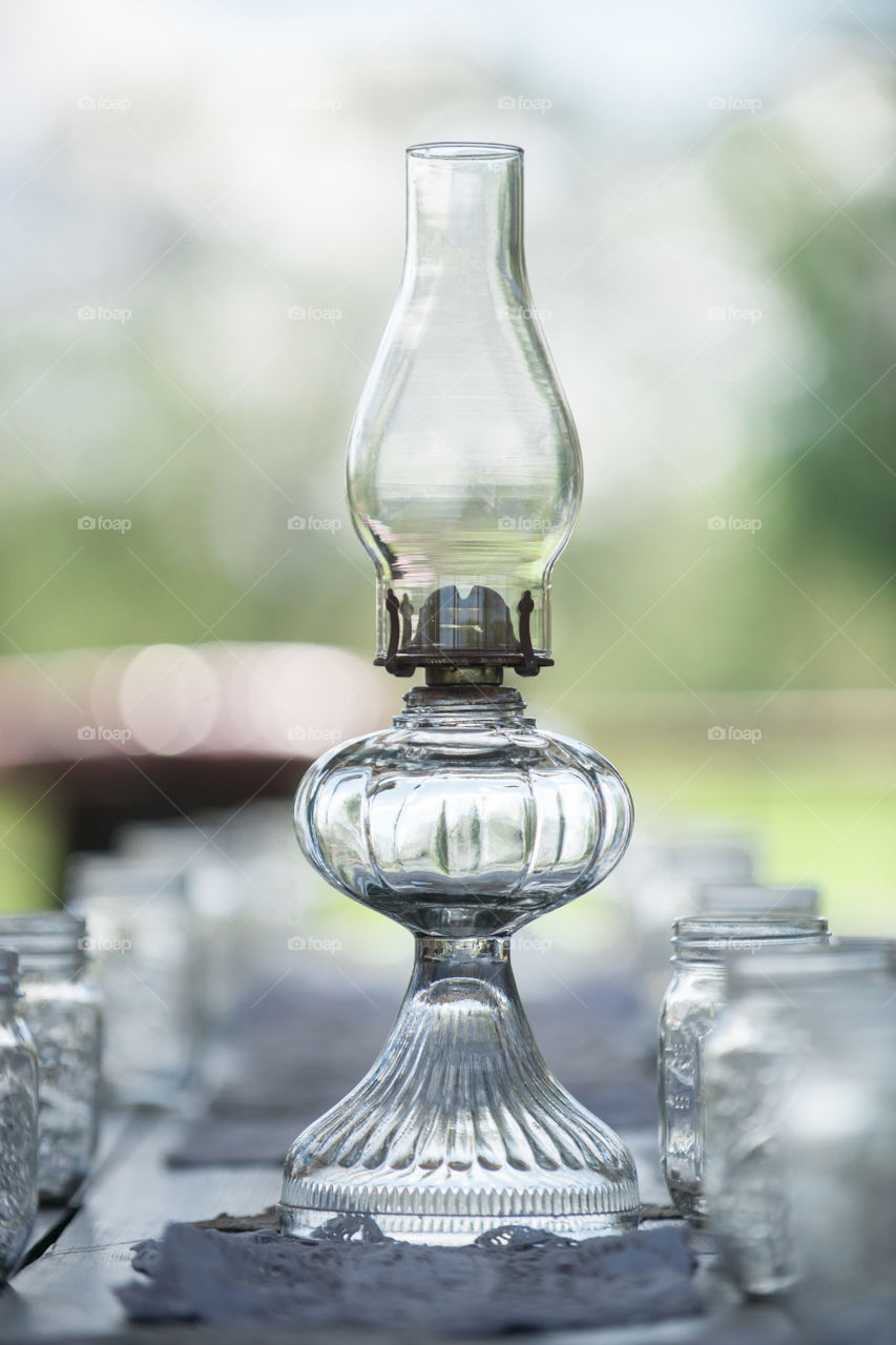 Glass oil lantern at outdoor picnic table setting
