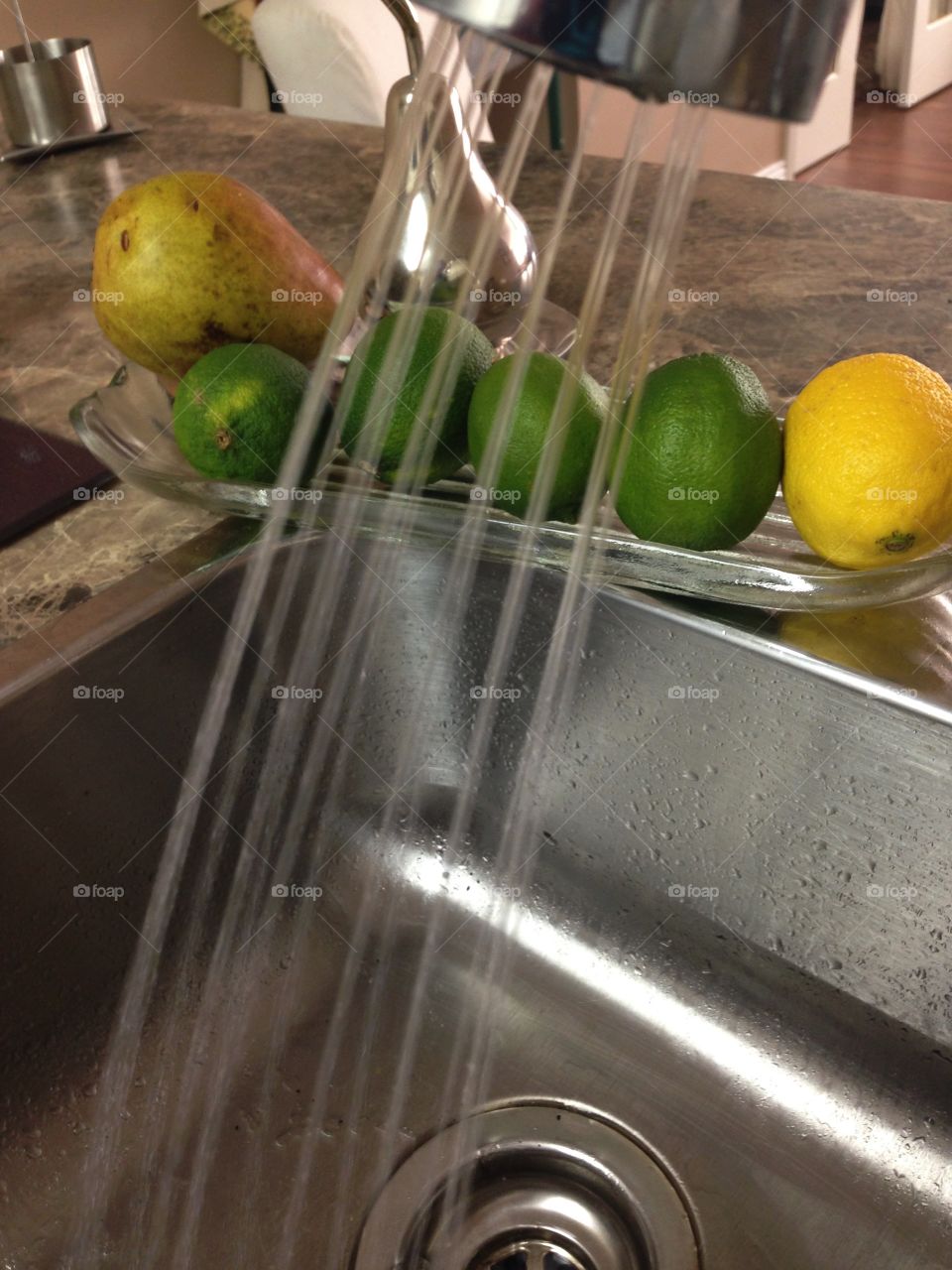 Running tap at kitchen sink. Preparing to wash some fruit