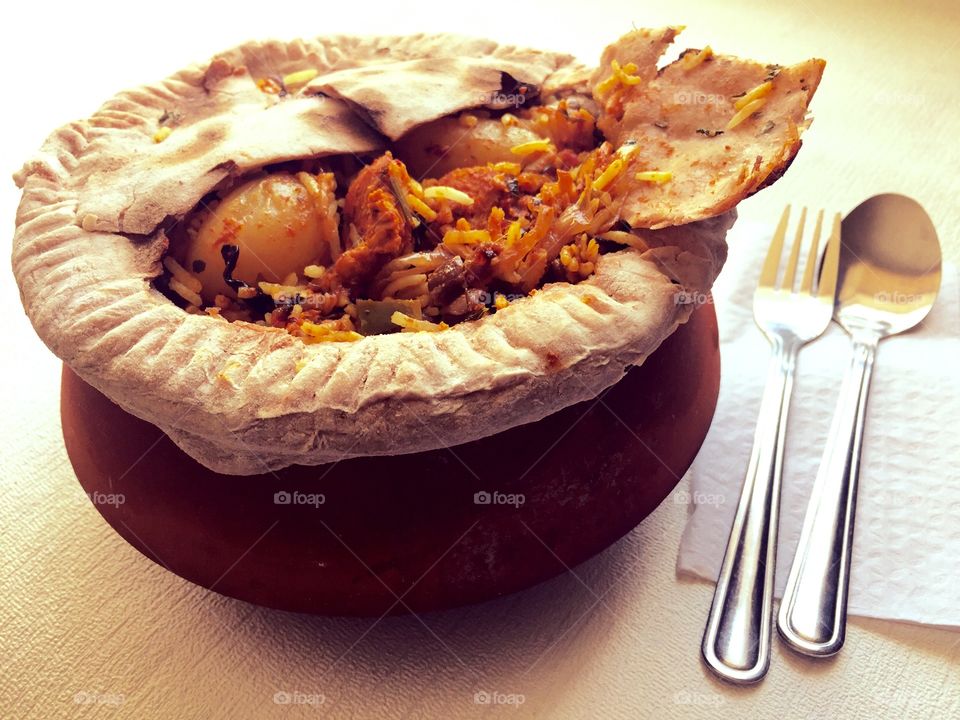 My authentic style homemade  chicken Biryani ( indian spicy rice ) in a clay pot, covered with dough on top and was left for slow cooking..