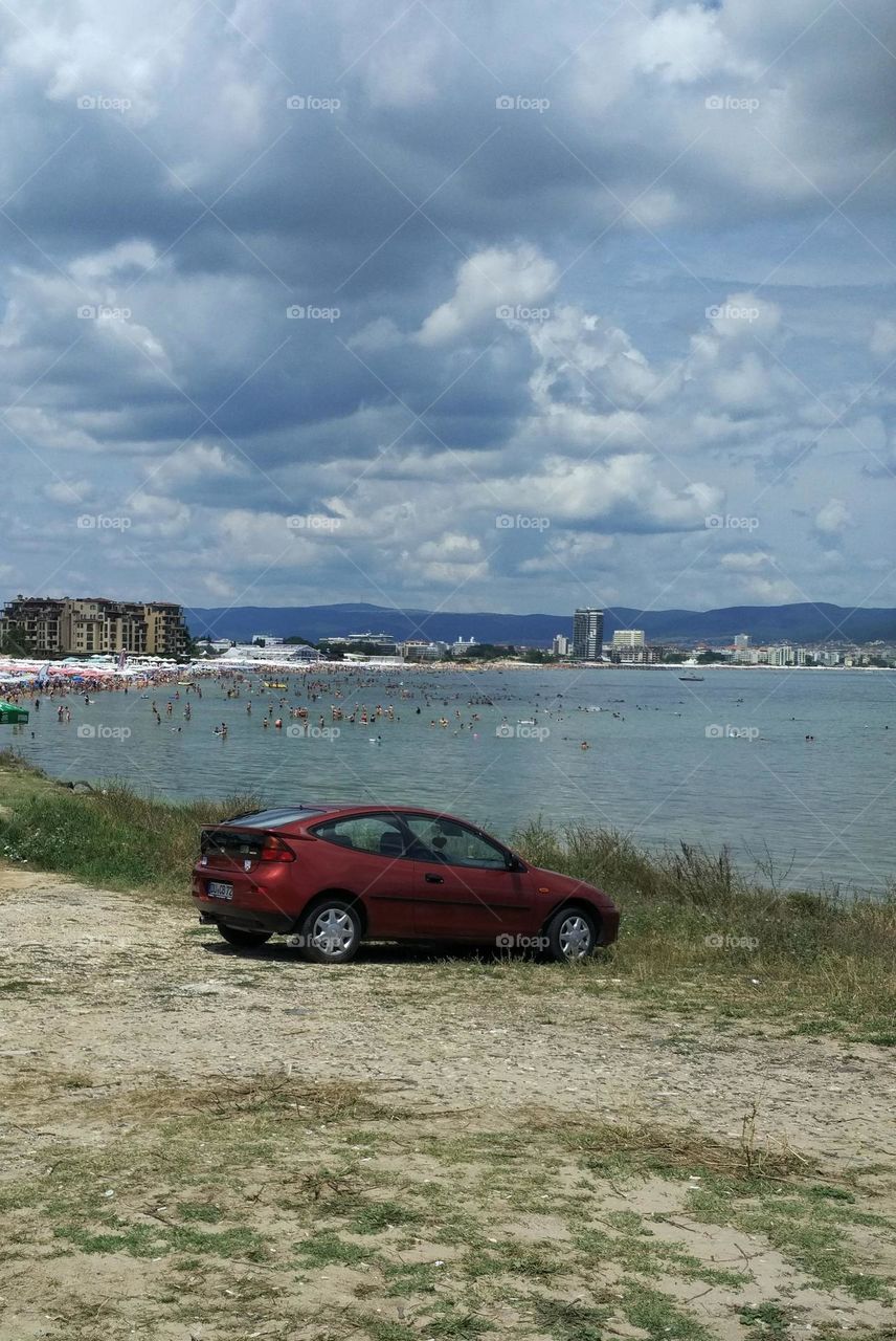 red car on the black sea lit by the sun