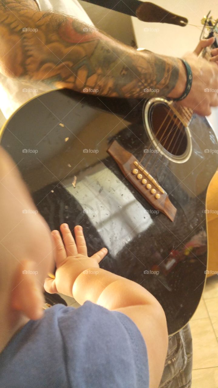 Baby listening to Dad play guitar