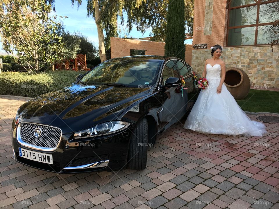 Wedding model girl standing with premium black Jaguar car
