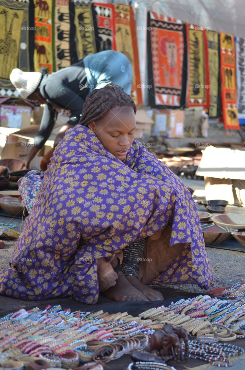 African woman selling bangles in market