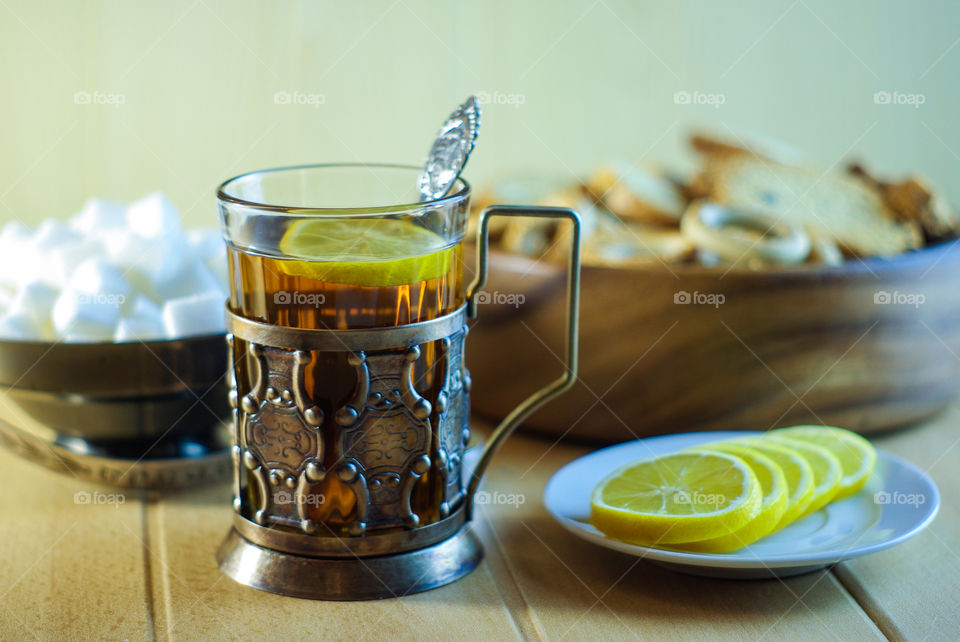 Tea in a glass in an old cup holder with drying and lemon