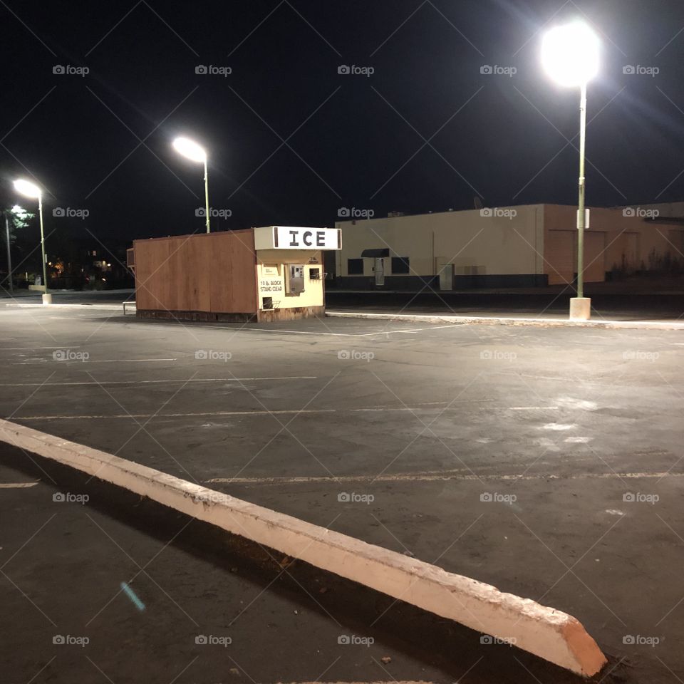 Ice dispenser in a lonely parking lot at night