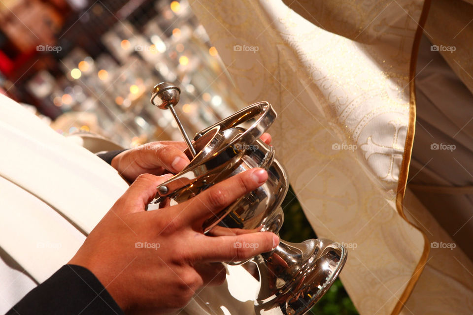 Priest holding holy water chaliz on a religious ceremony celebration