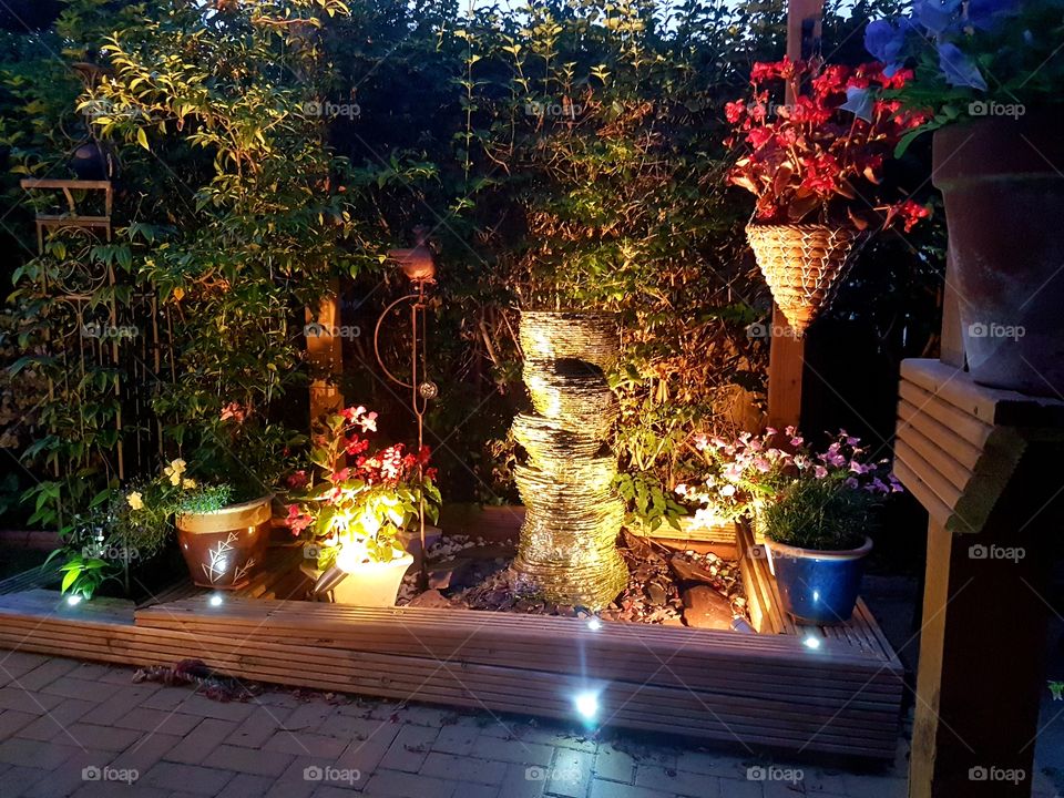 Night time photo of a garden with water feature