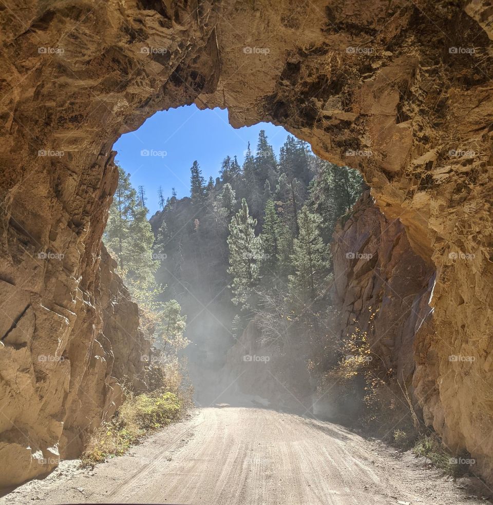 national park tunnel on narrow dirt road in summer