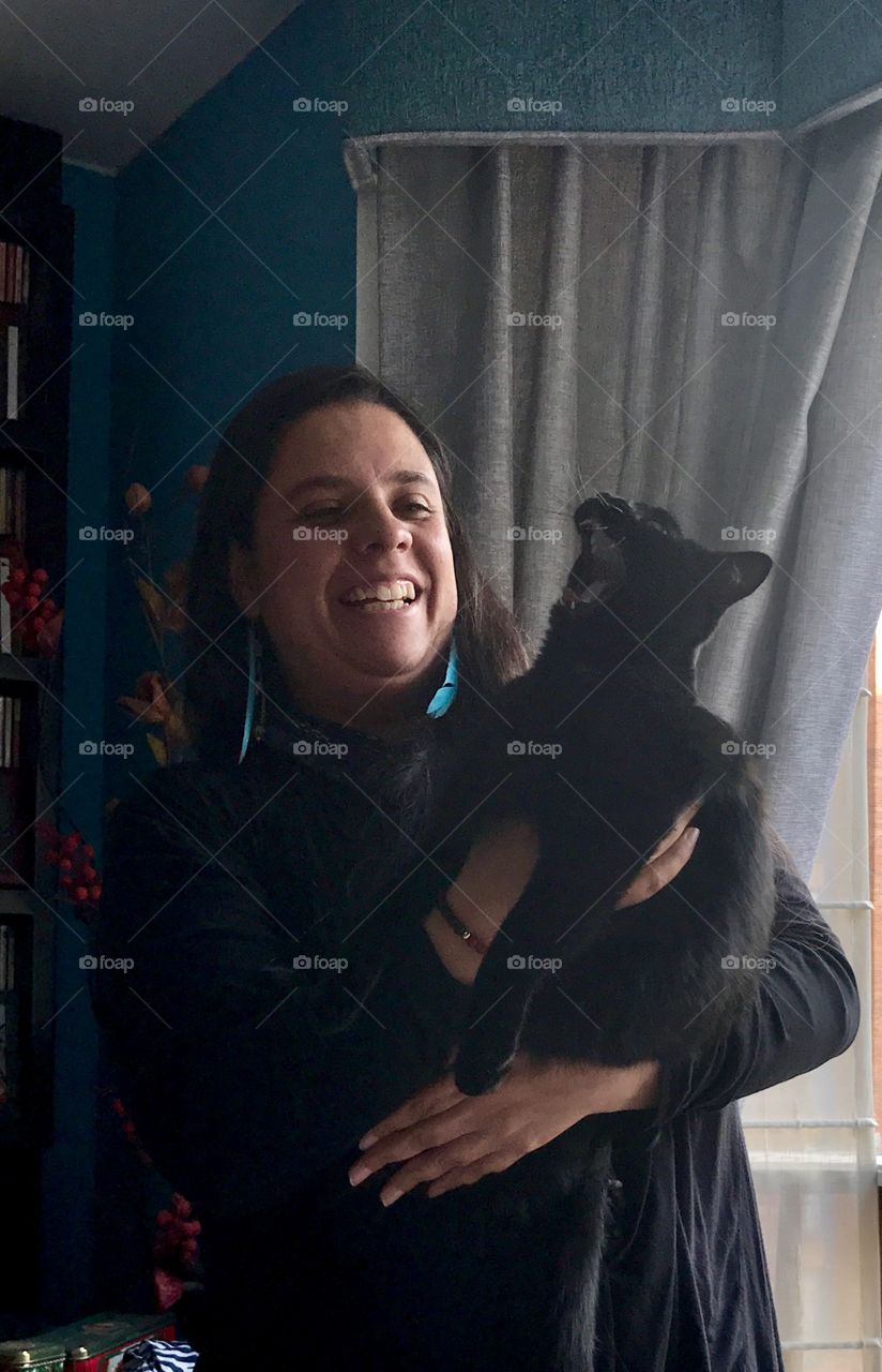 Woman carrying her black cat