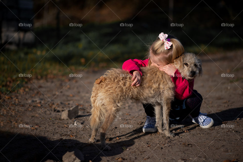 Cute girl hugging dog from shelter