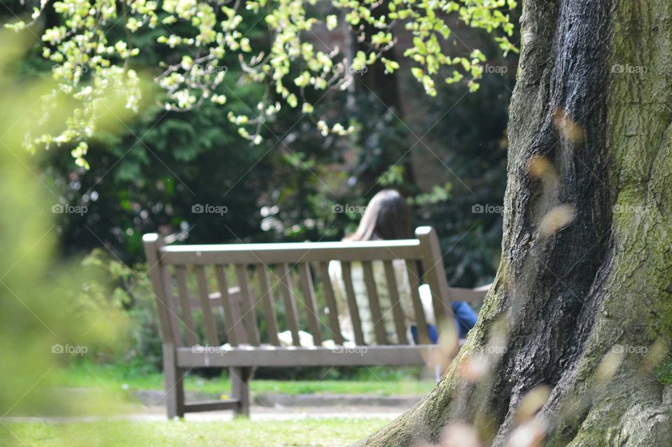 Young woman sitting alone on a park bench