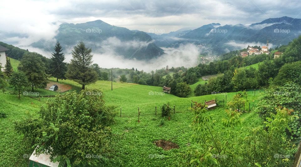 Clouds on a green valley after the rain.Alpine landscape under a cloudy Sky, Italy 