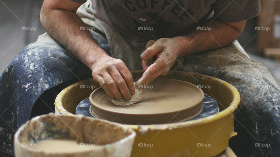 Close-up of potter's hands making pottery