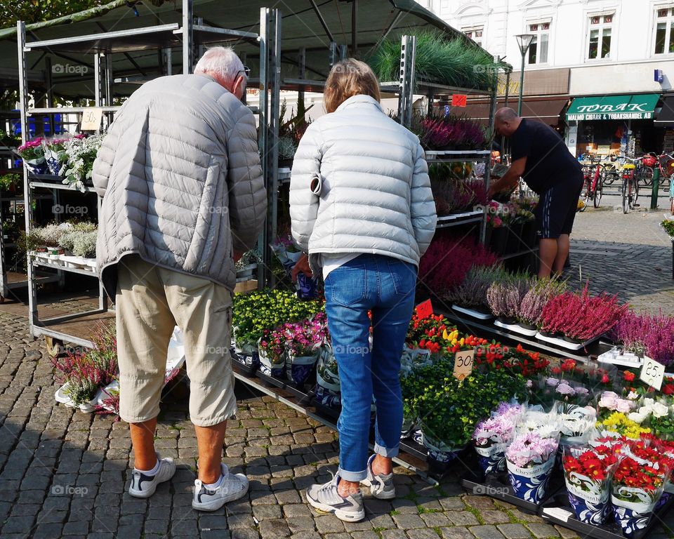 Elderly people shopping plants outdoors at the marketplace 