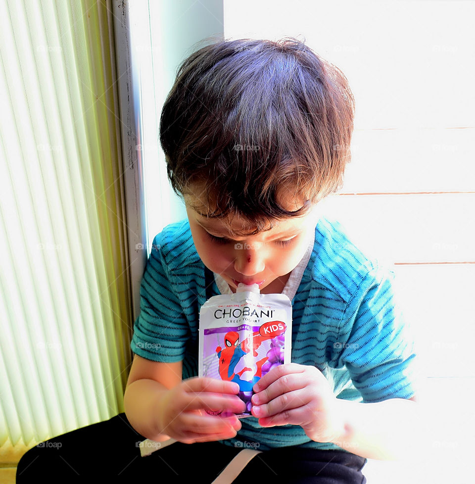 Close-up of a boy eating yogurt