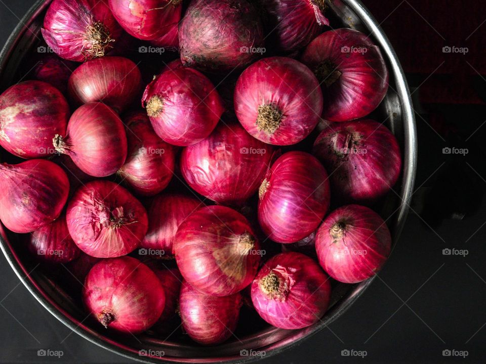 Fresh onions in a stainless steel container