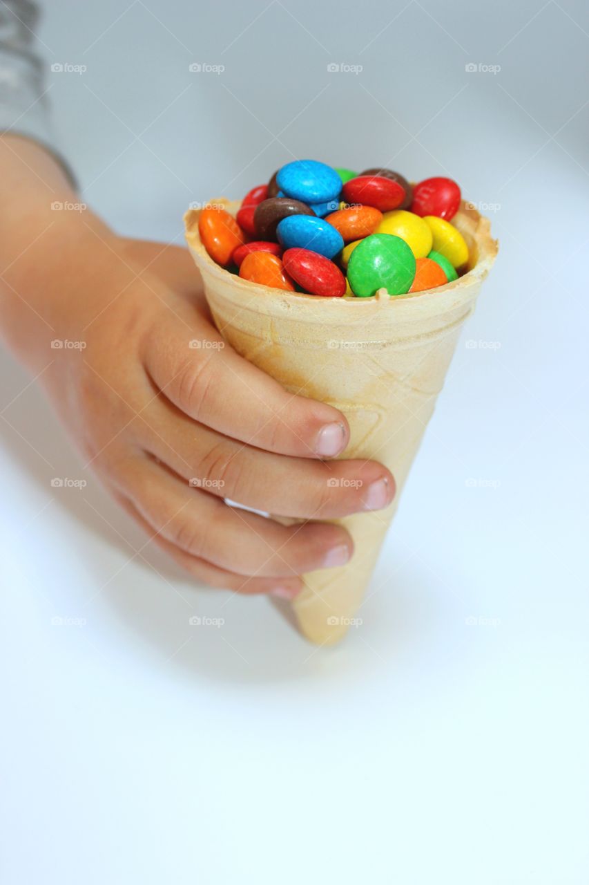 waffle cone with colored dragee in hand