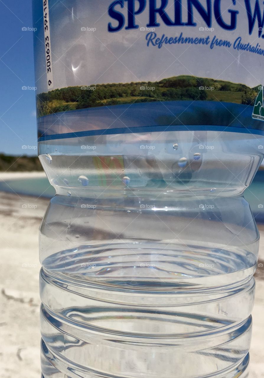 Remote pristine tropical ocean view through a spring water water bottle perspective 