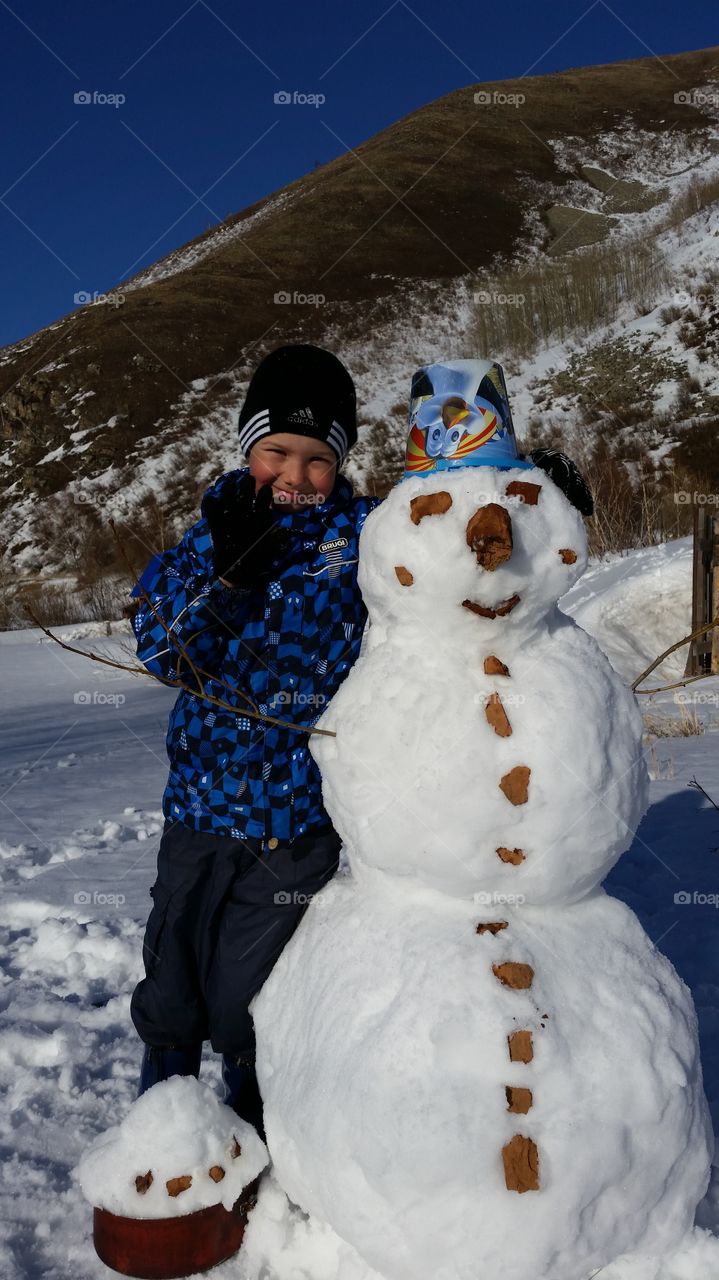 boy and snowman. winter holidays