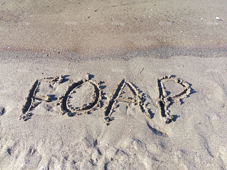 foap letters written in the beach sand