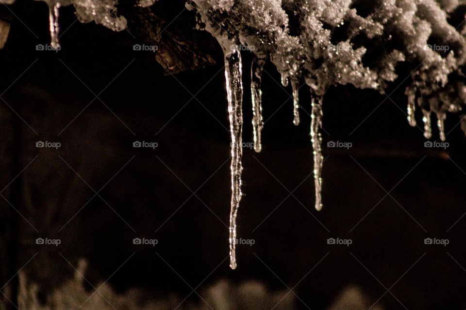 ice hanging off the edge of a snow covered ledge