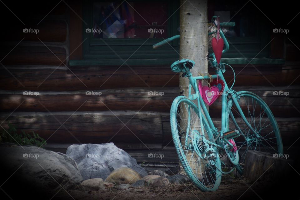 Turquoise bike parked against a pole