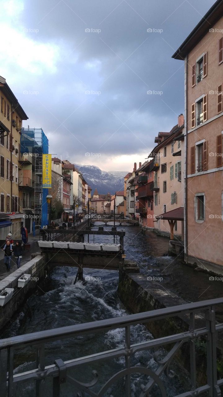 View of colorful buildings from a bridge in the downtown area of Annecy, France.