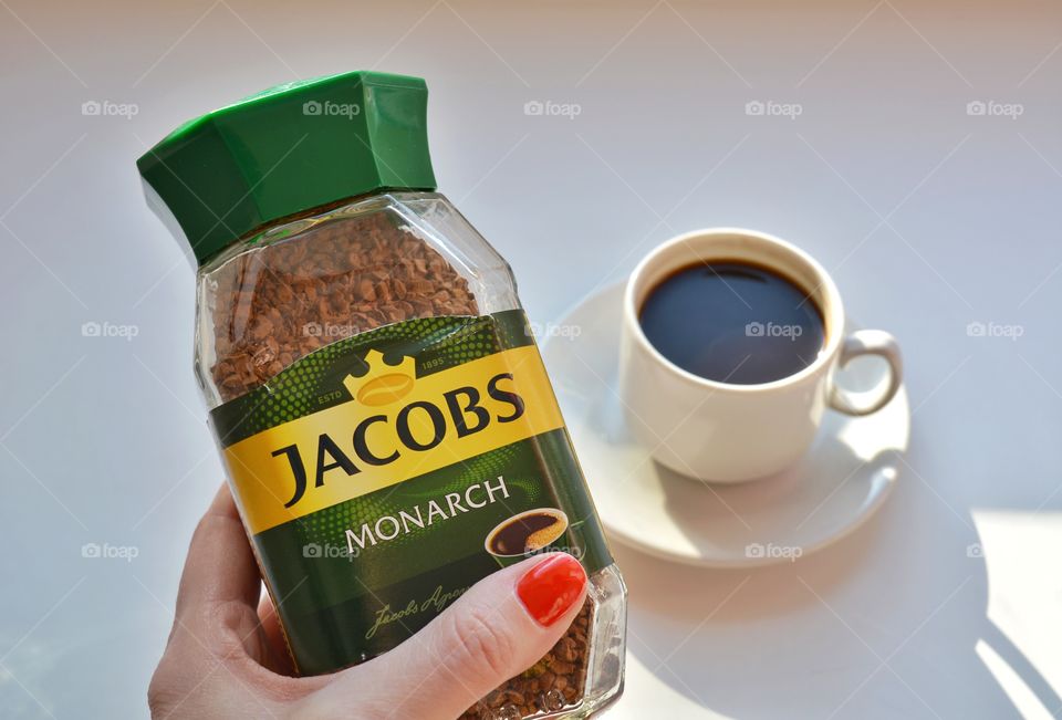 coffee Jacobs in the female hand and coffee mug on a white background, morning routine