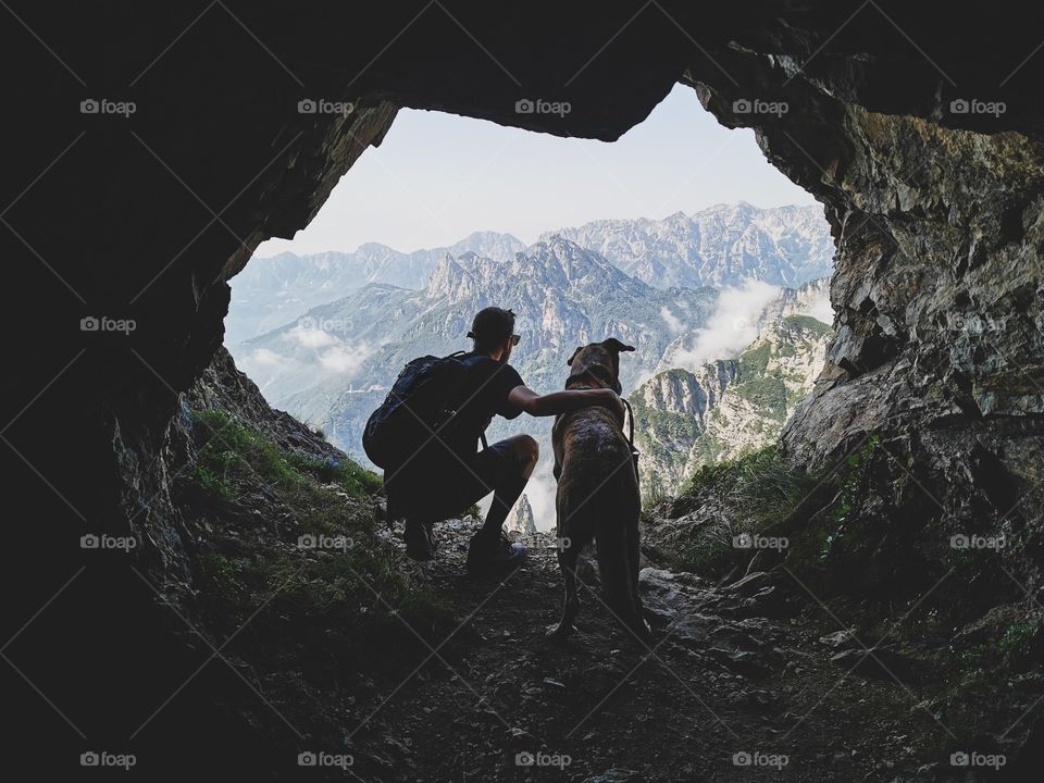man with dog against mountains