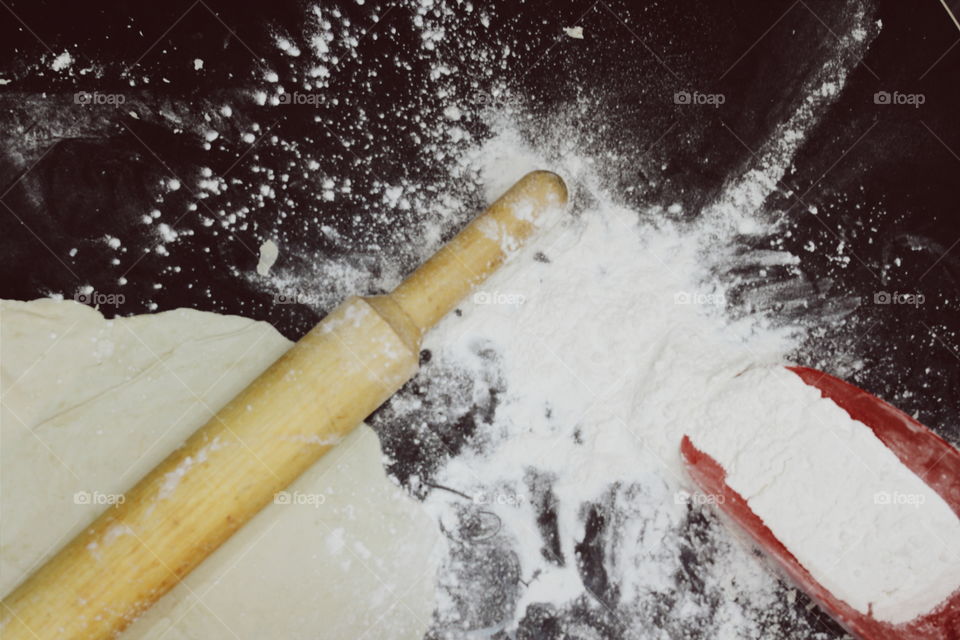 Dough with rolling pin on wooden table
