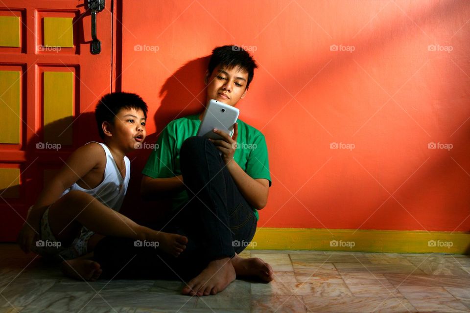 young asian children with a tablet in a living room