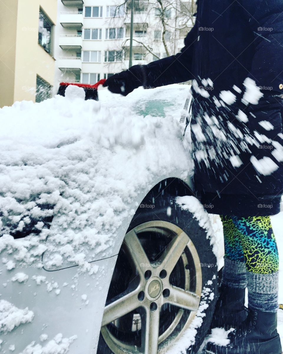 Brushing snow from a car