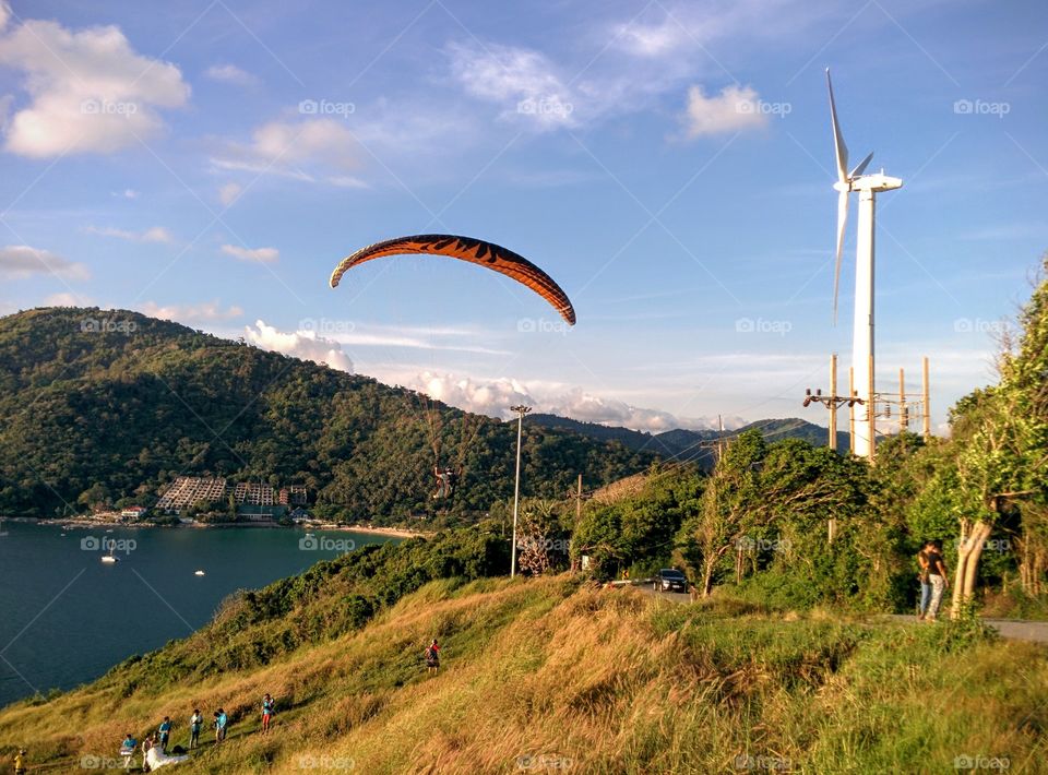 Paragliding at Nai Harn. Evening at windmill viewpoint, Rawai, Phuket, Thailand. Sometimes in evening, you can see paragliders flights here.
