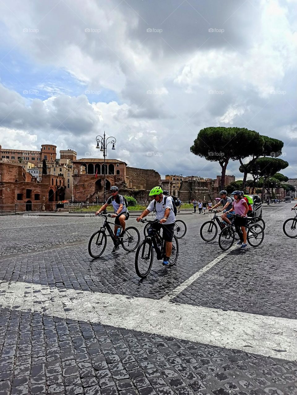 a group of cyclists rides through the city. Rome.