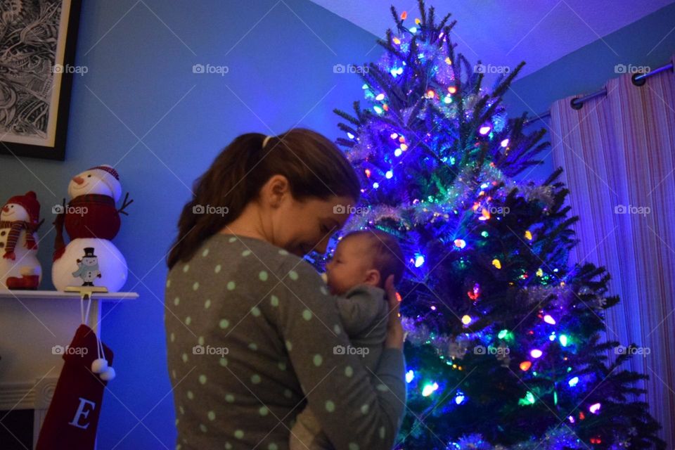 Mom and her baby enjoying the glow from the Christmas lights 