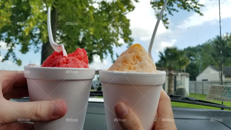 A cherry snowcone and a dream sicle snowcone cheering on summer!