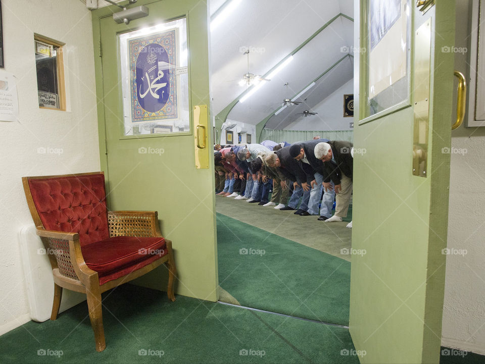 Men pray during a Muslim prayer service at a community center.