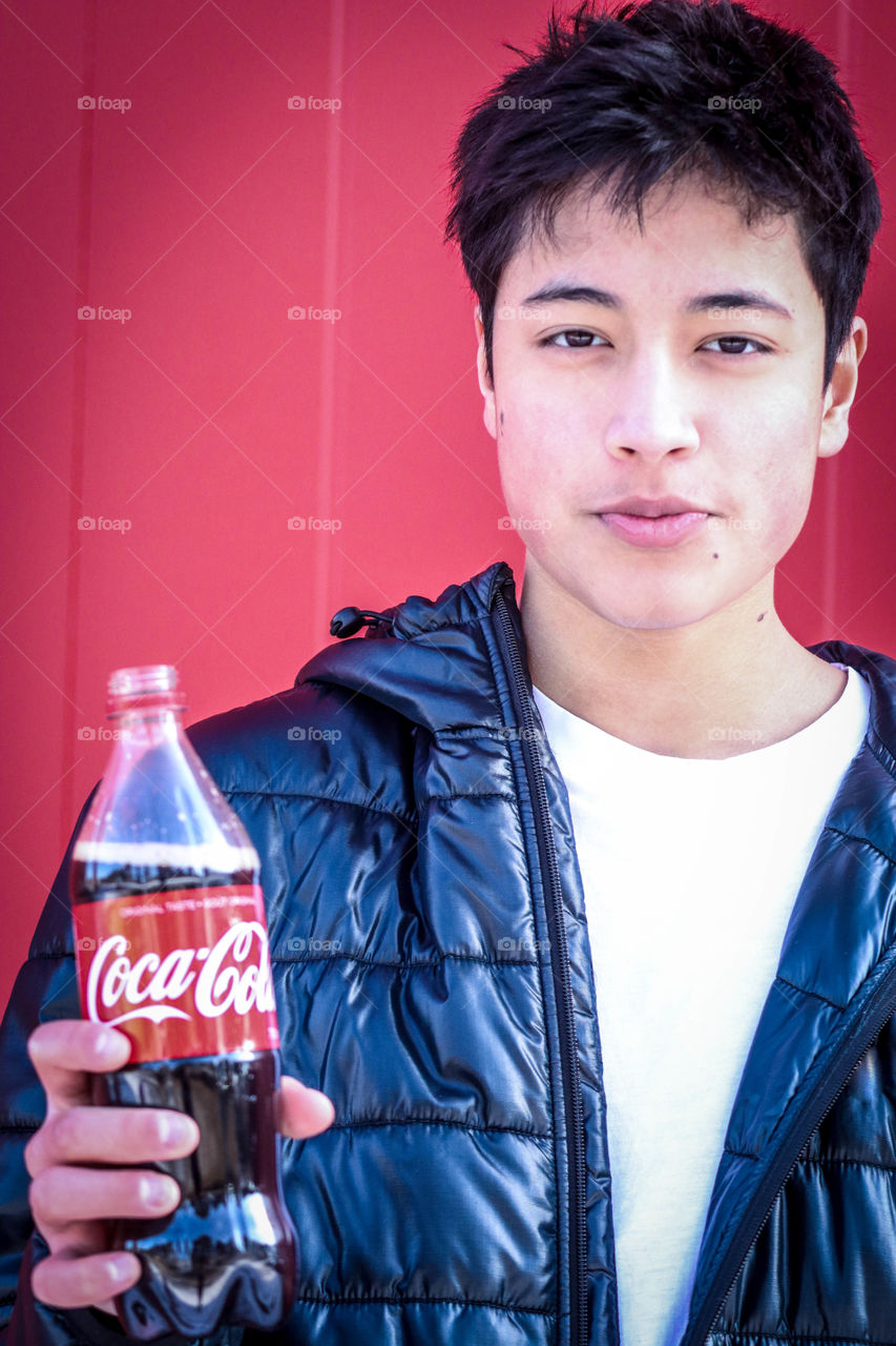 Young handsome man with a bottle of Coca-Cola