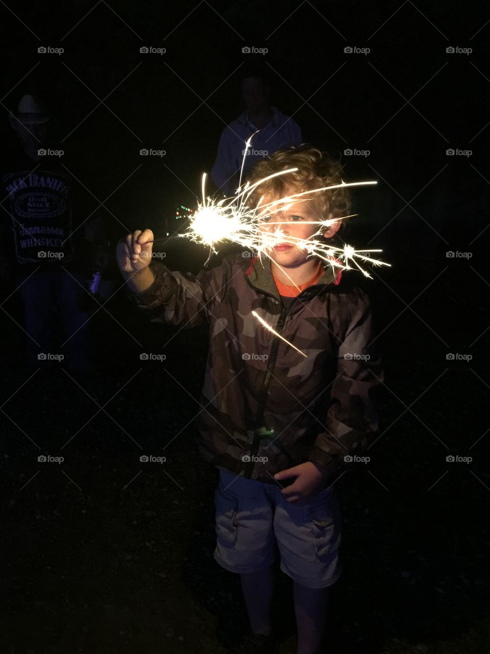 Little boy holding sparkling cracker