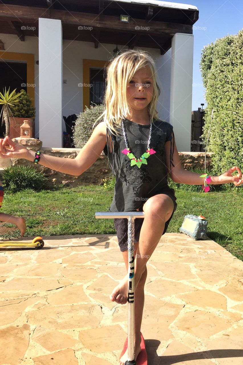 Girl doing yoga on a scooter