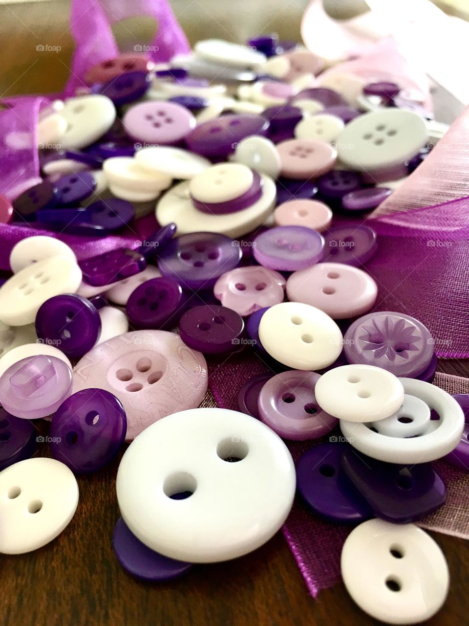 Collection assortment of various shades of vintage lavender colour clothes buttons, background selective focus background 
