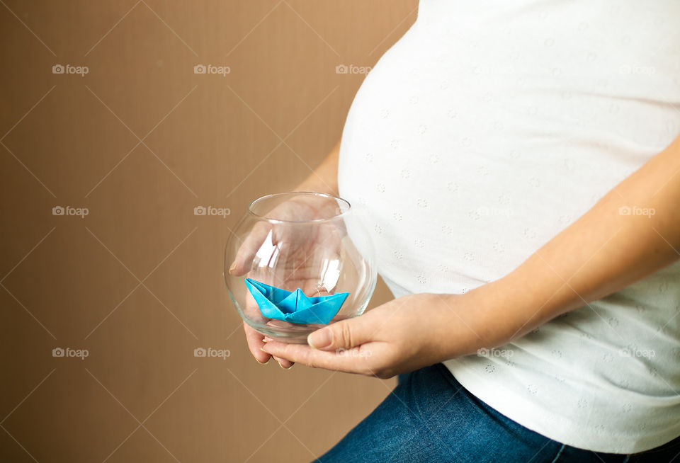 Pregnant woman holding glass jar