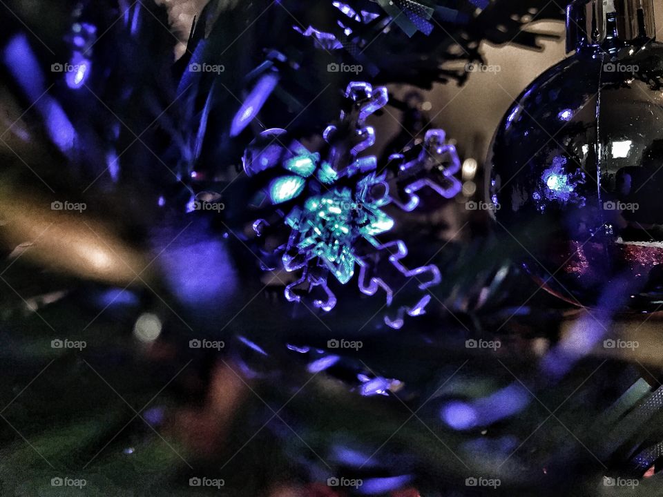 Snowflake Christmas light through the tree 