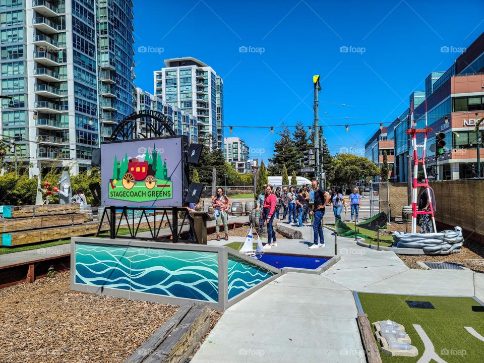 Playing mini golf at stagecoach green in the San Francisco south of market area on a warm summer afternoon 